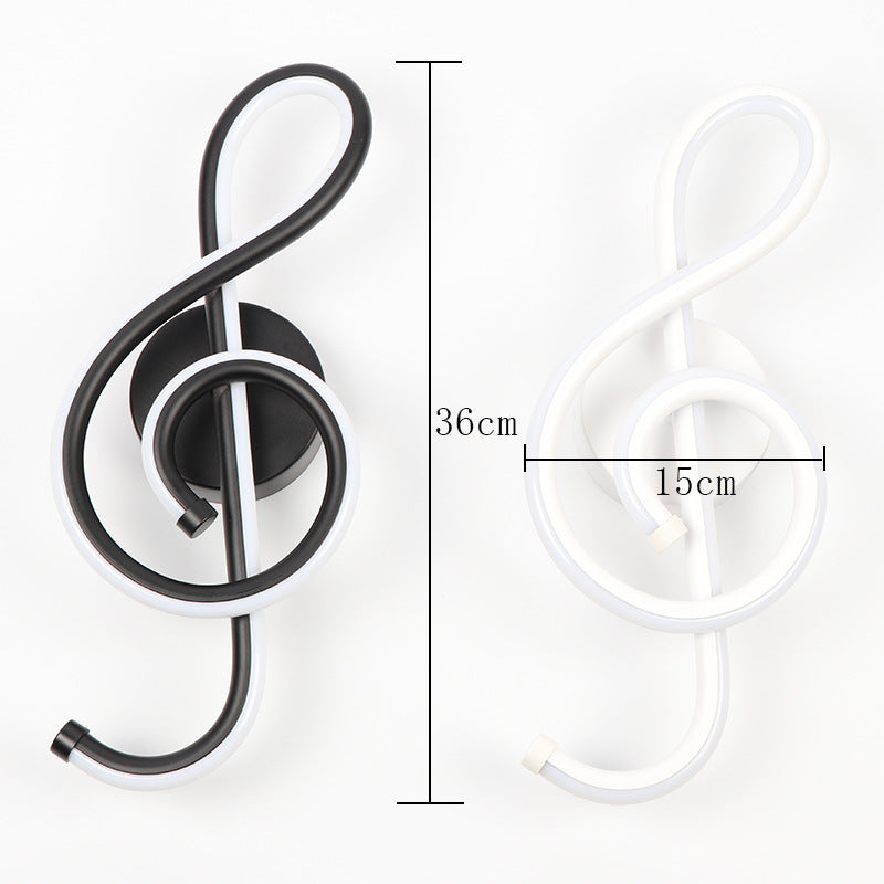Black treble clef wall light fixture with measurements on a white background